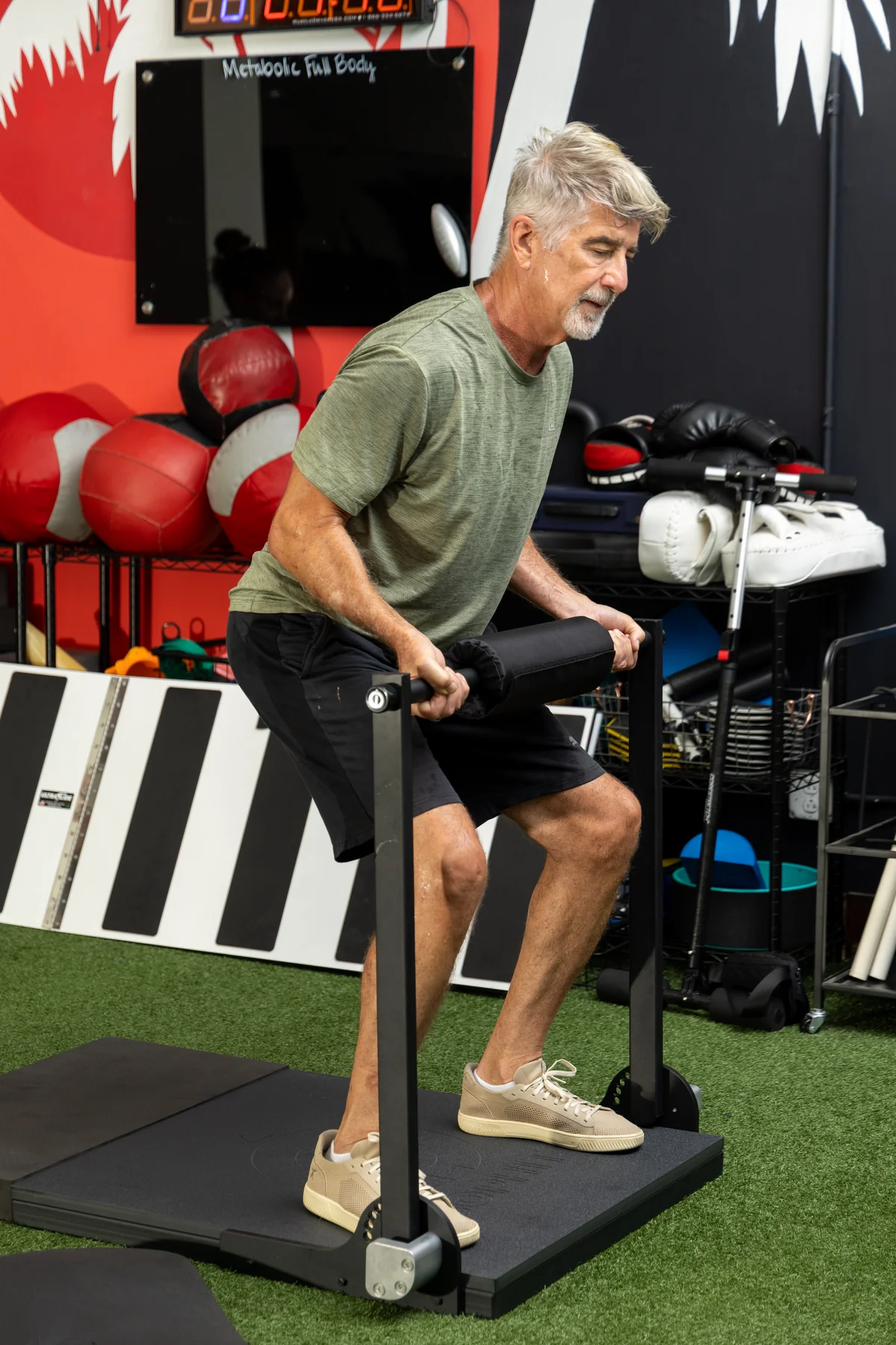 Coached ISOPHIT Strength Training Adult performing a coached ISOPHIT strength exercise at Primal Fit Miami